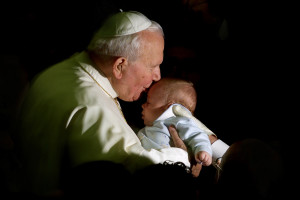 Pope John Paul II kisses a baby before his weekly general audience at the Vatican November 28, 2001. The Pope indirectly condemned human cloning on Wednesday, rejecting experiments he said constitute threats to life. The 81-year-old Pontiff spoke three days after the U.S. researchers said they had cloned a human embryo for the first time. REUTERS BOOKS Pope John Paul II Reaching Out Across Borders REUTERS/Paolo Cocco     PP03090123 HIGHLIGHTS PC/CLH/JM - RTRPWVS